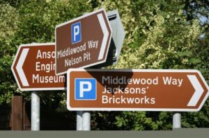 Cluster of brown directional road signs indicating local points of interest, including Anson Engine Museum and Middlewood Way with parking areas at Nelson Pit and Jacksons’ Brickworks, used to guide travelers to recreational or historical destinations.