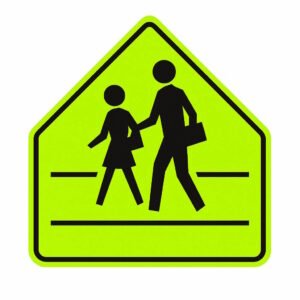 A fluorescent yellow-green pentagon-shaped traffic sign depicting two pedestrians, typically an adult and child, crossing the road, used to indicate a school crossing zone and alert drivers to reduce speed and watch for children.