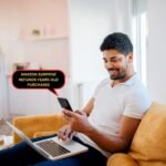 Happy man sitting on yellow couch with laptop and smartphone checking Amazon surprise refunds for years-old purchases