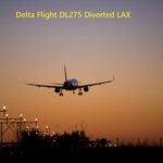 Delta Air Lines aircraft approaching LAX airport during sunset with runway lights visible after emergency diversion from Tokyo route