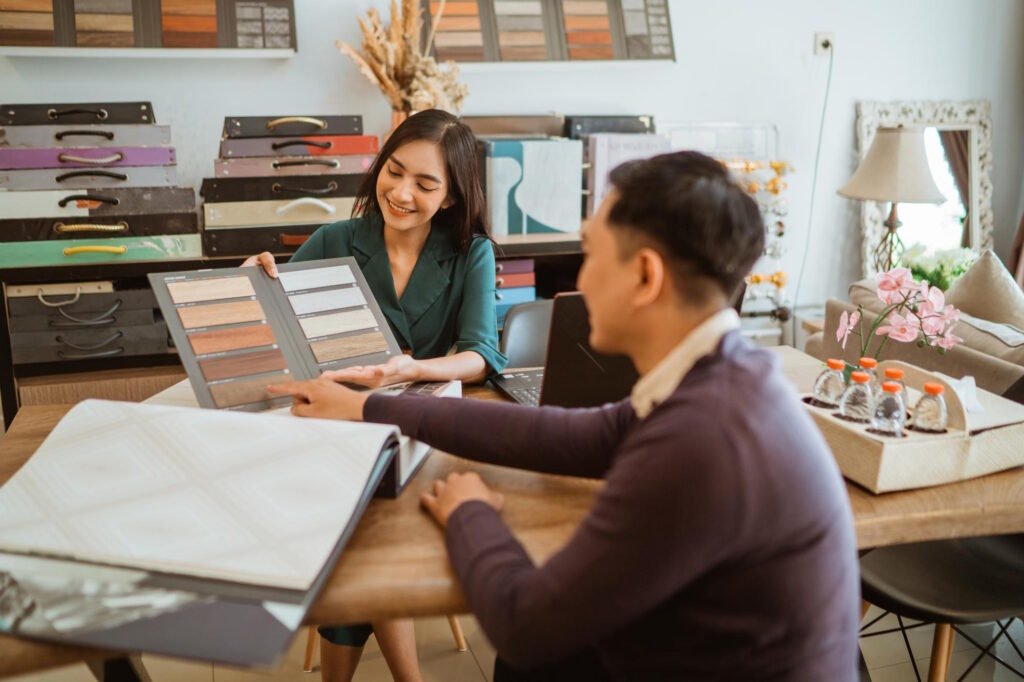 Professional interior designer showing material samples to client during home decoration consultation in modern office space