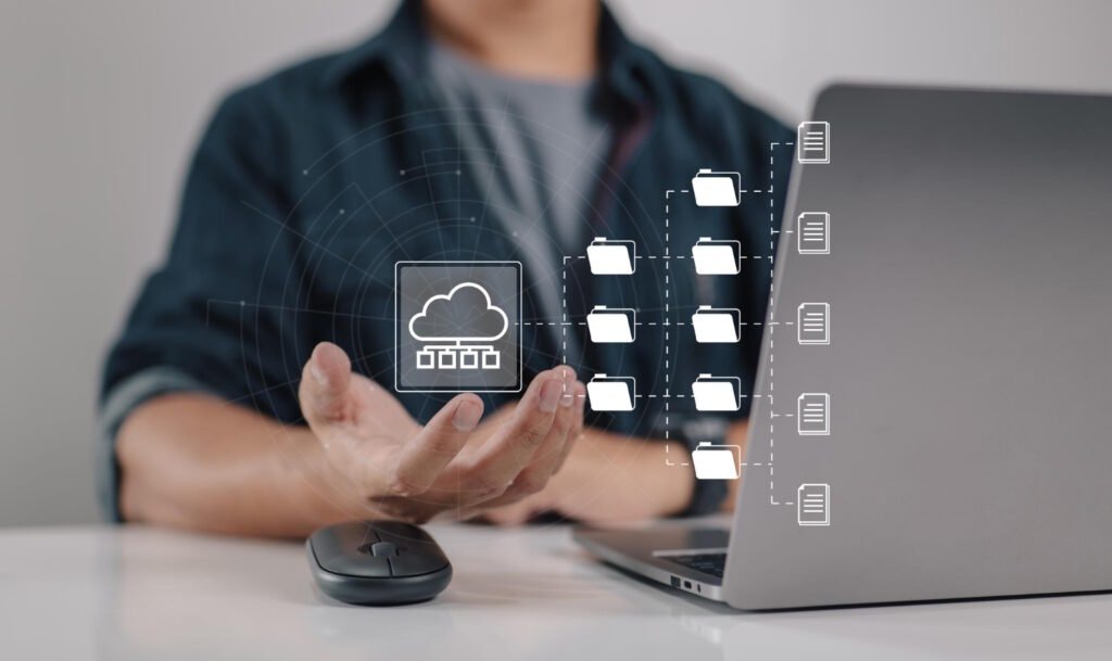 Professional demonstrating cloud storage management with digital folders and files flowing from laptop to cloud infrastructure.