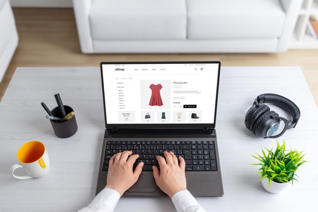 Person browsing an eShop website on a laptop, viewing a red dress product page with add-to-cart option.